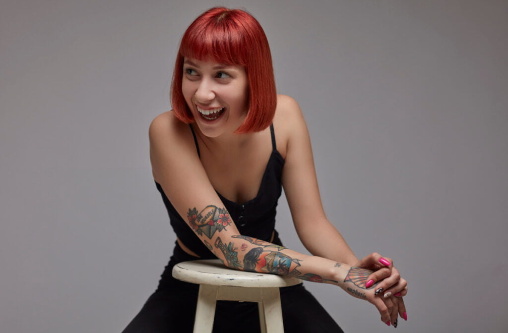 Woman with bright red hair and colorful tattoos