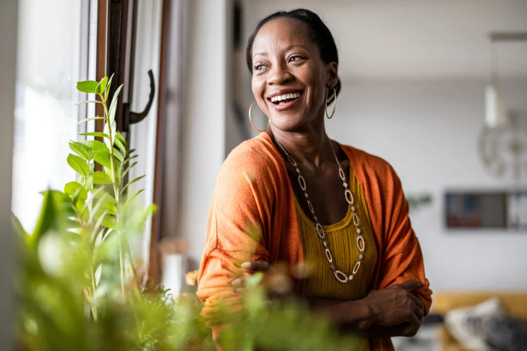 Woman smiling and looking out the window in her home