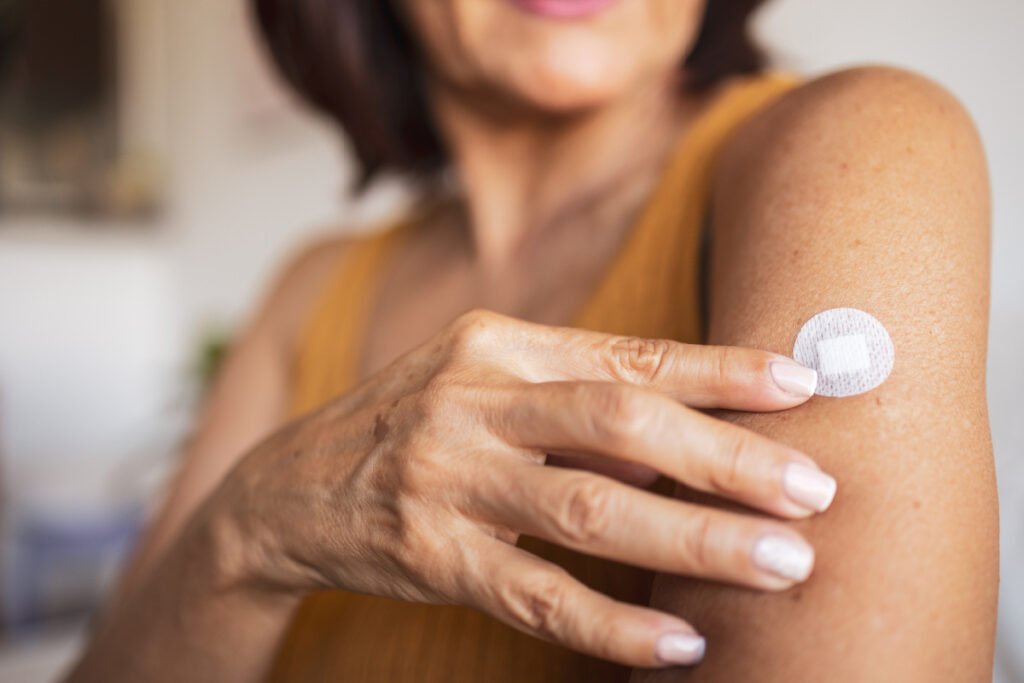 Woman applying patch as part of hormone replacement therapy regimen