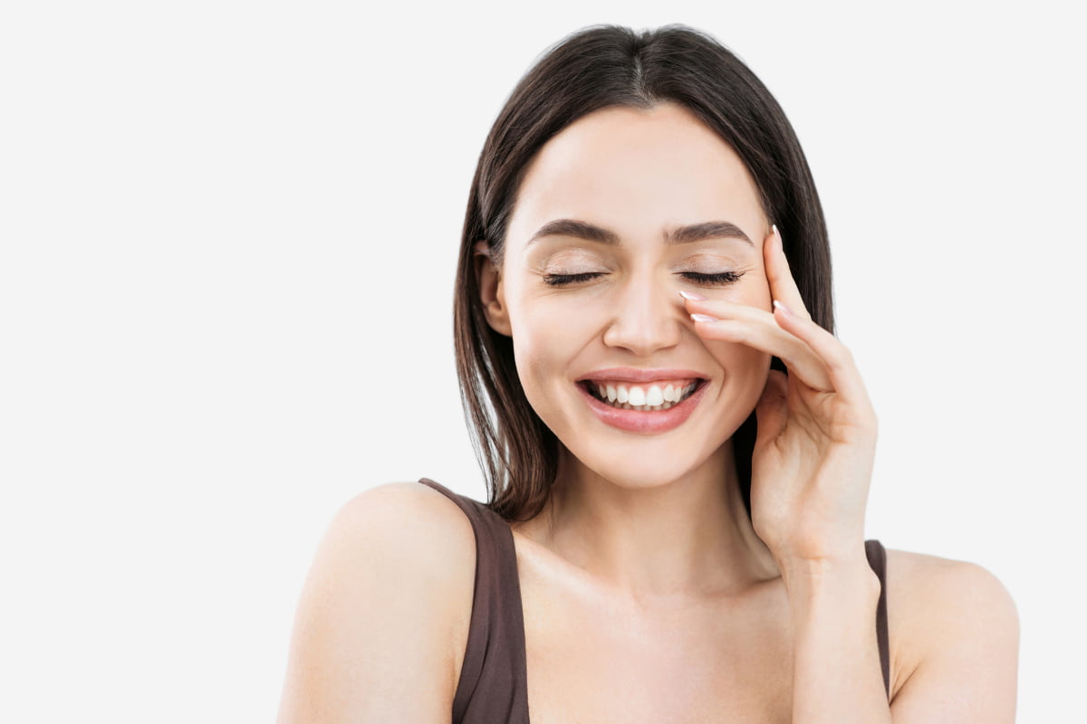 Young woman smiling and touching face