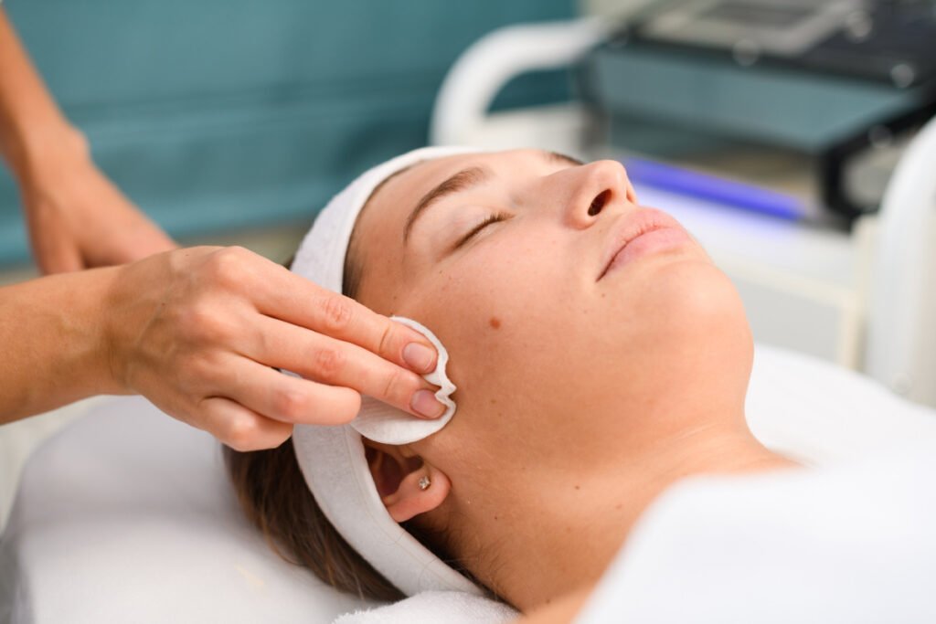 Med spa provider applyin exosomes with a cotton pad during a non-surgical skin treatment