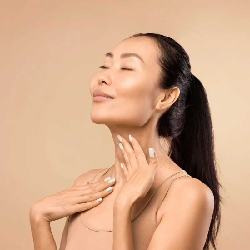 Middle-aged Asian woman touching her neck