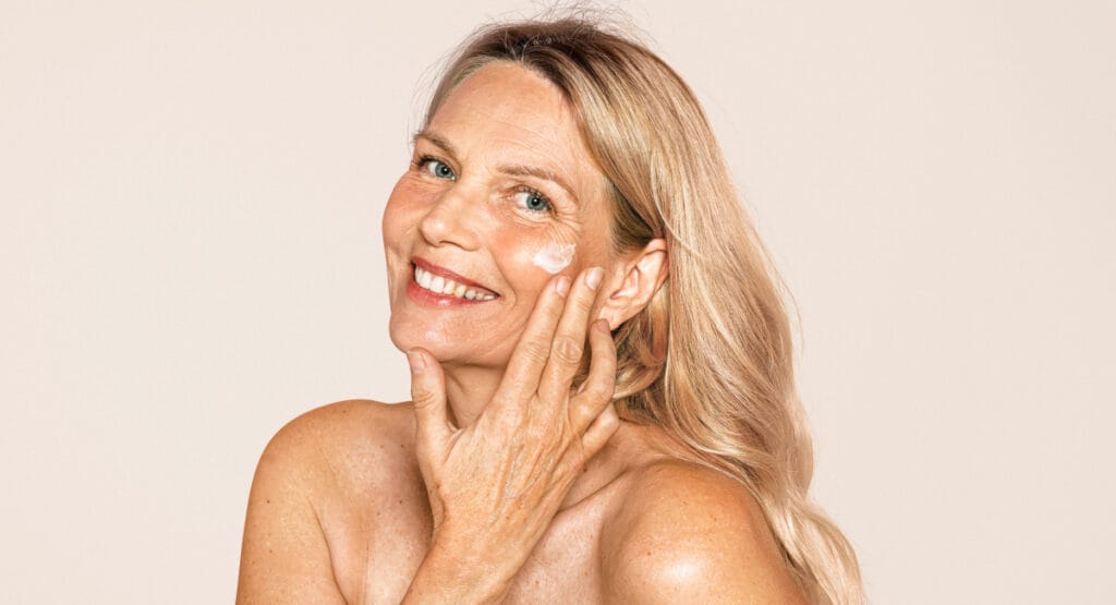 Mature woman applying skincare